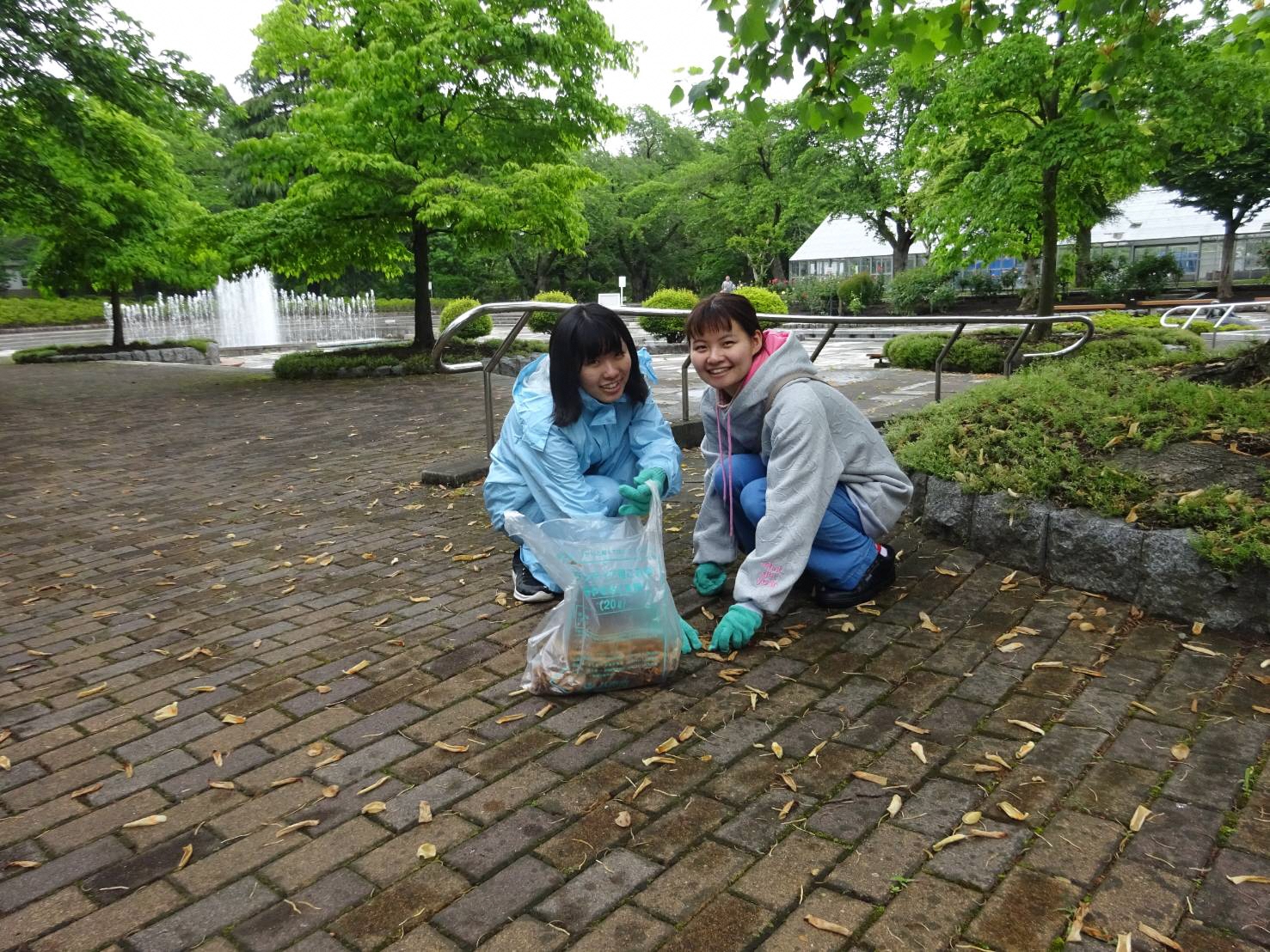 八戸公園内でごみを拾っている二人の女性の写真