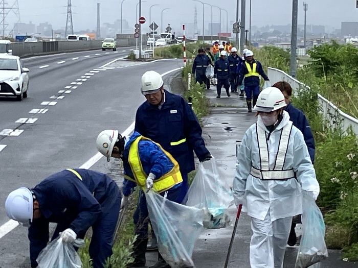 国道45号線道路脇をヘルメット姿でごみを拾っている写真