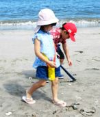 砂浜でトングをもって歩いている子供たちの写真