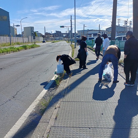 歩道のごみを拾いごみ袋に入れている参加者の写真