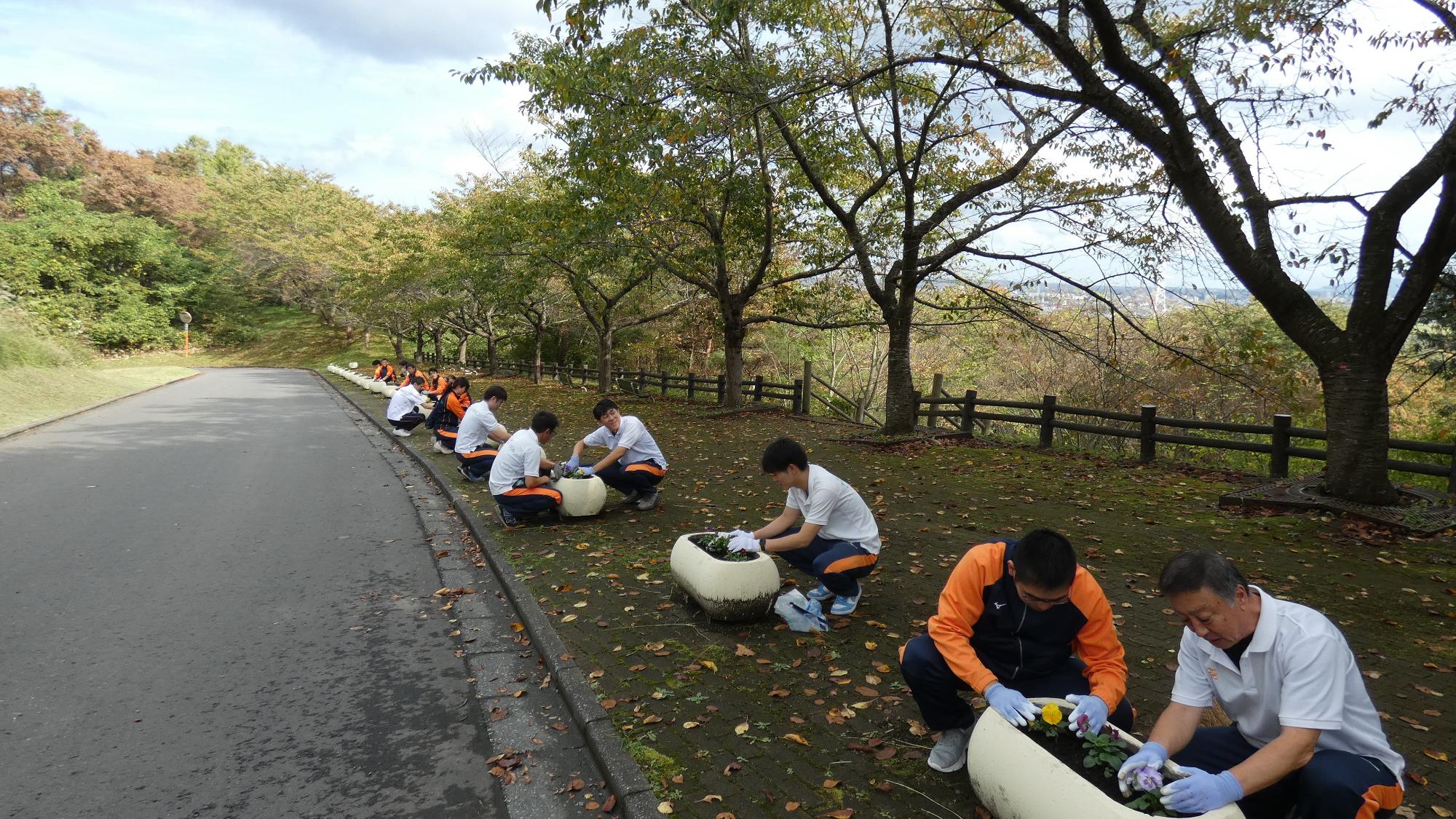 フラワーポットに提供していただいた花を植える参加者の写真