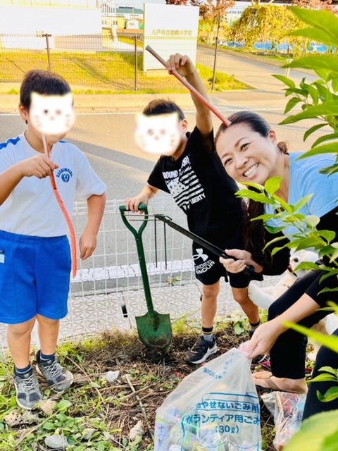 ごみ拾いに参加してくれた児童二人と女性の写真。