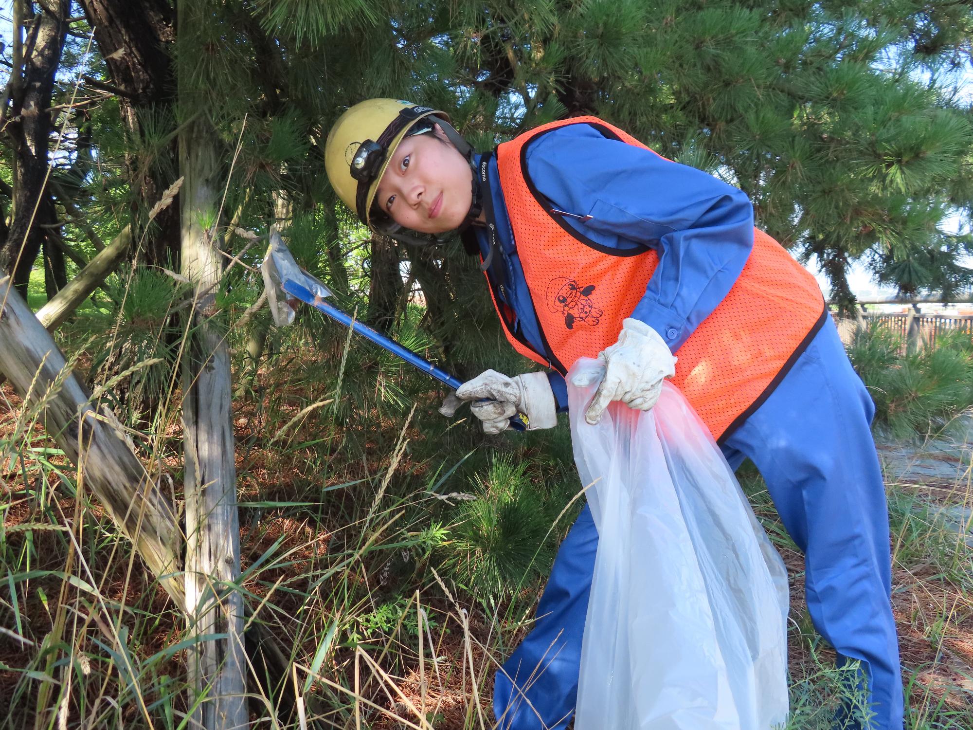 道路脇の草地のごみを拾う写真3