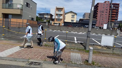 道路脇のごみを拾う写真