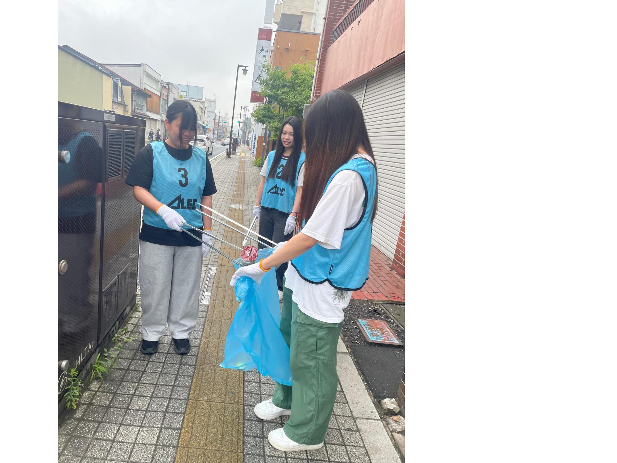 道路脇の草地のごみを拾う写真 3