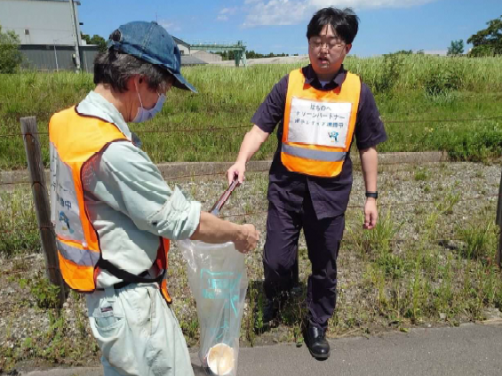 道路脇の草地のごみを拾う写真1