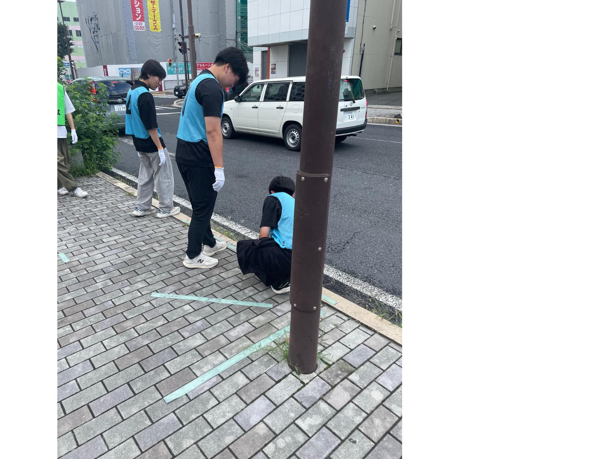 道路脇のごみを拾う写真