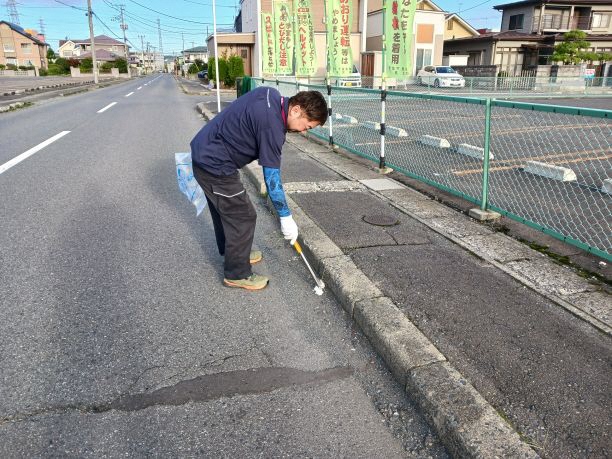 道路脇の草地のごみを拾う写真1
