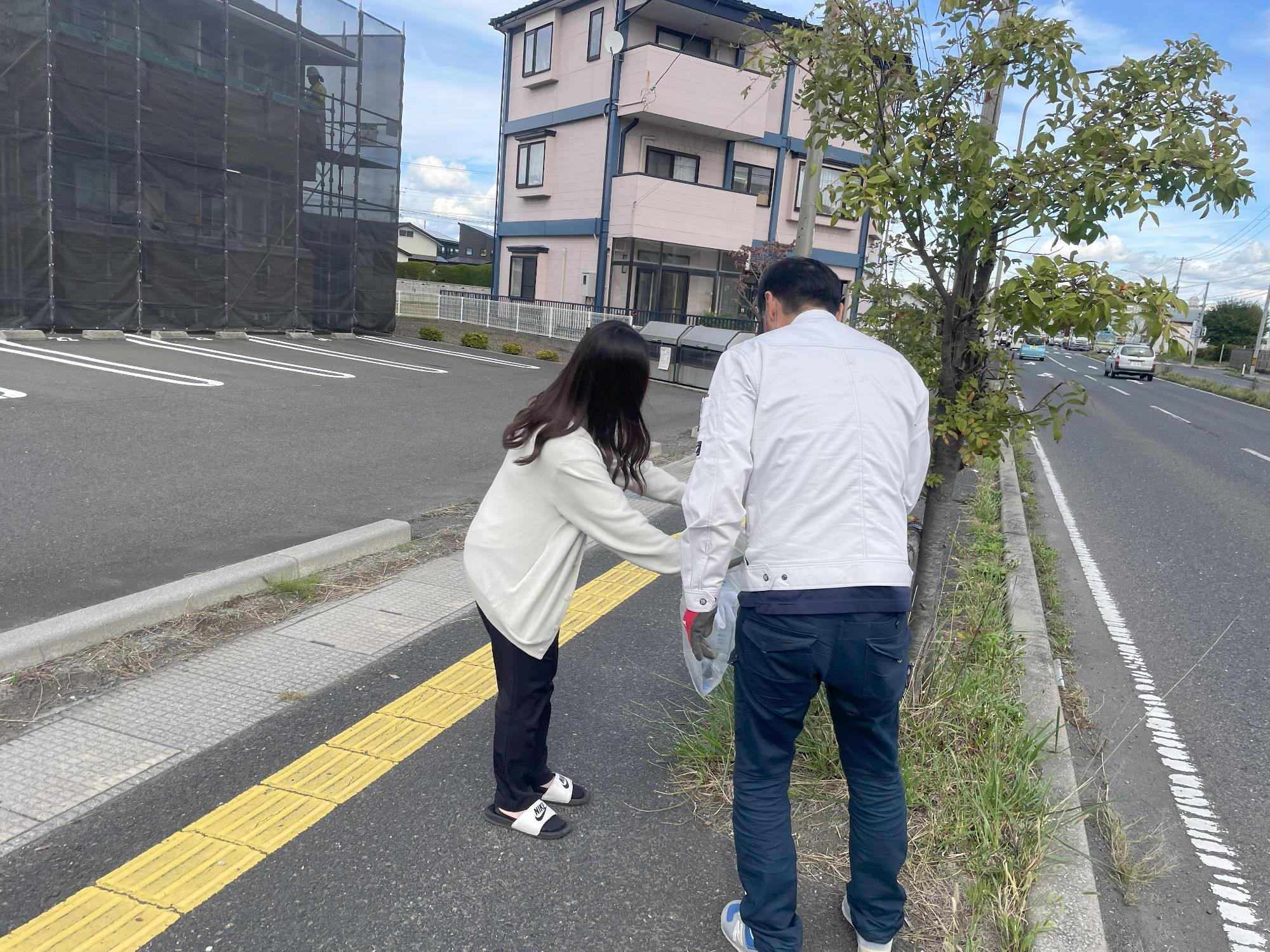 道路脇の草地のごみを拾う写真2