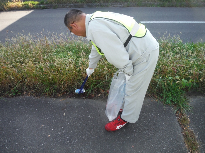 道路脇の草地のごみを拾う写真2