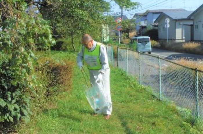 道路脇の草地のごみを拾う写真3