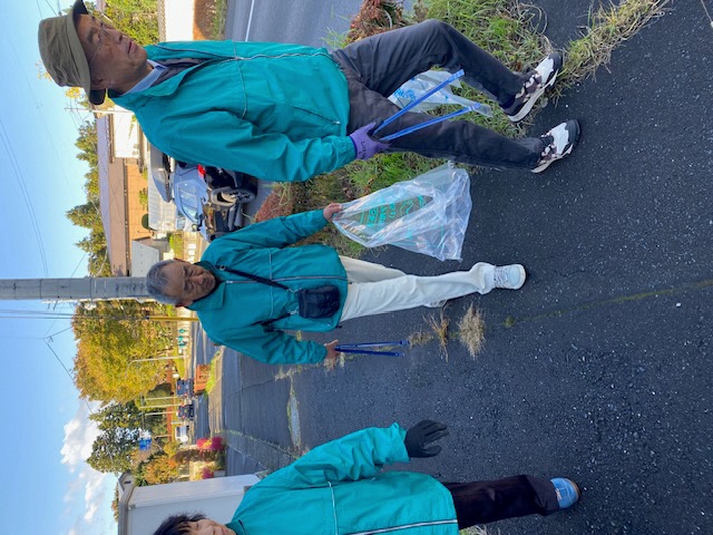 道路脇の歩道のごみを集めている参加者3人の写真3