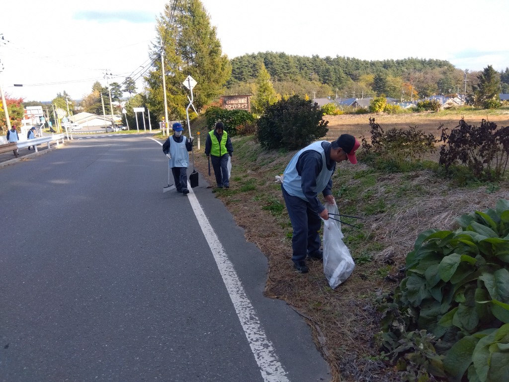ほうきと塵取りを持って清掃する様子
