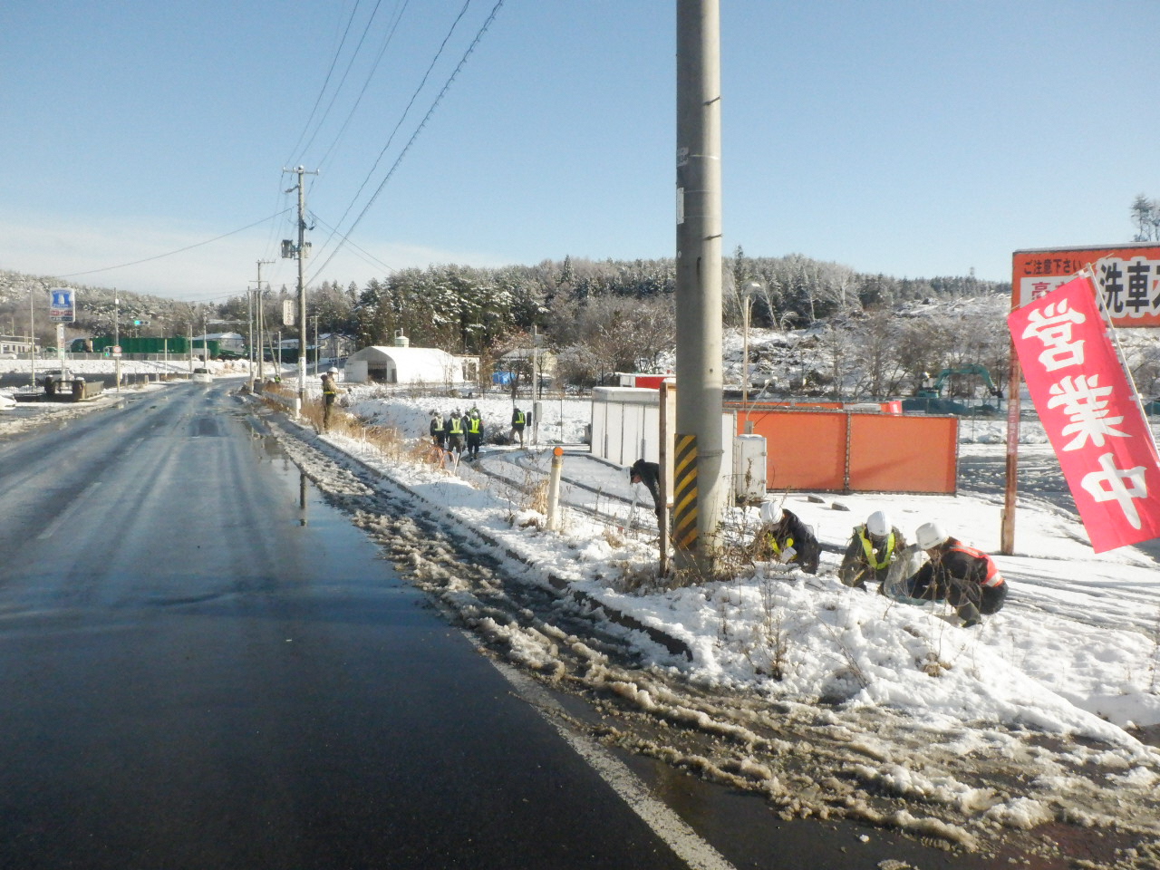 道路脇の草地のごみを拾う写真