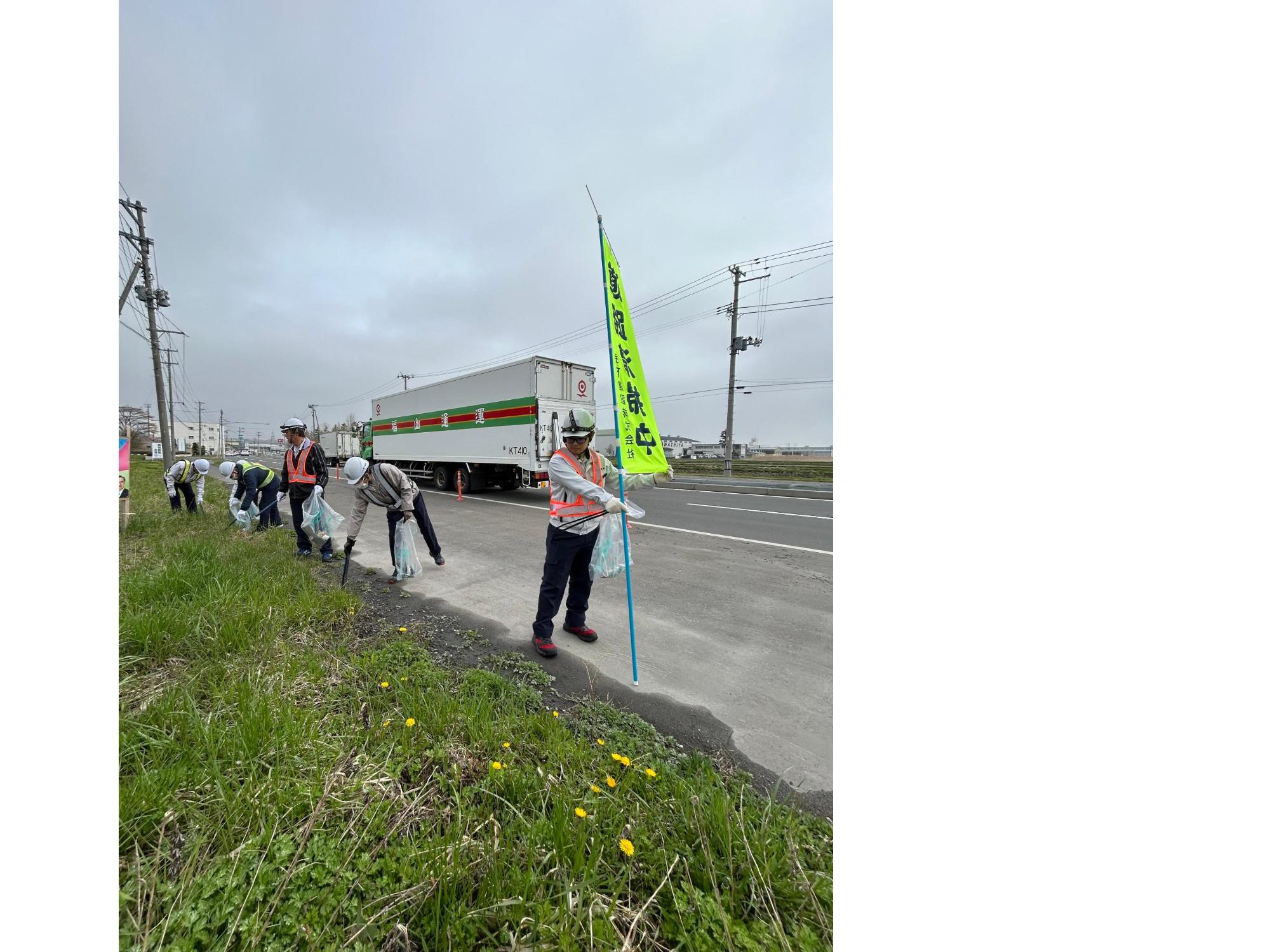 道路脇の草地のごみを拾う写真 2
