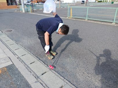 道路脇の草地のごみを拾う写真1