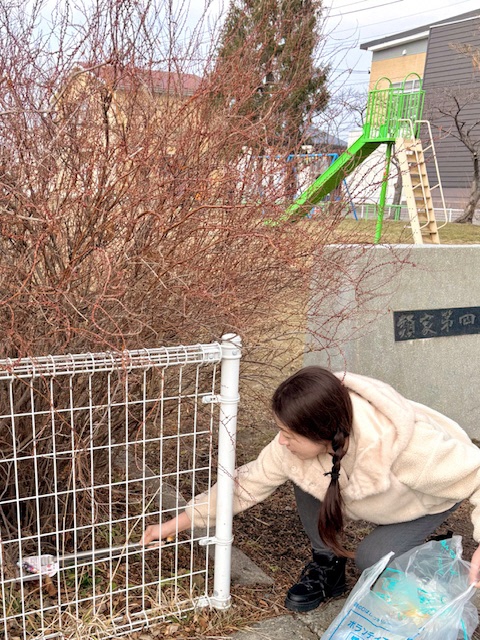 親子で公園のごみを拾う写真