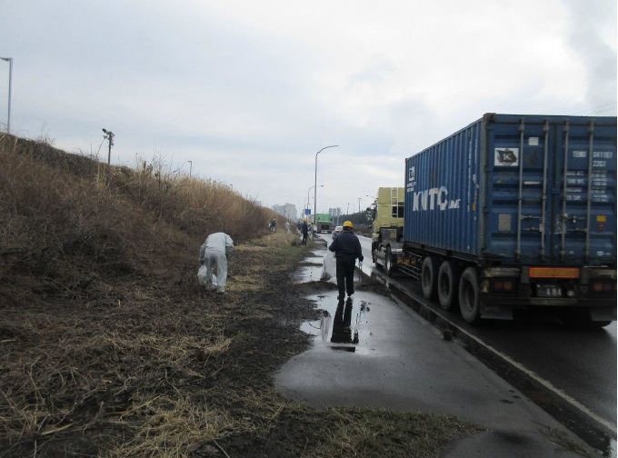 道路脇の草地のごみを拾う写真2