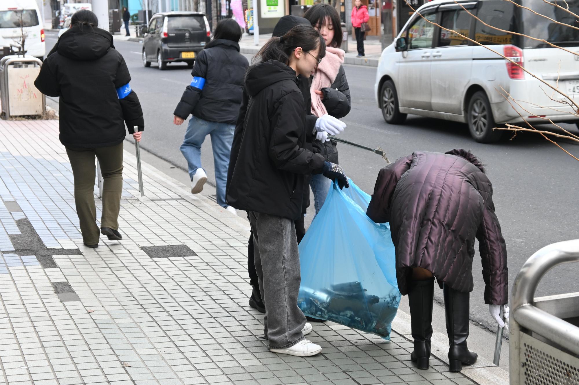 道路脇のごみを拾う写真