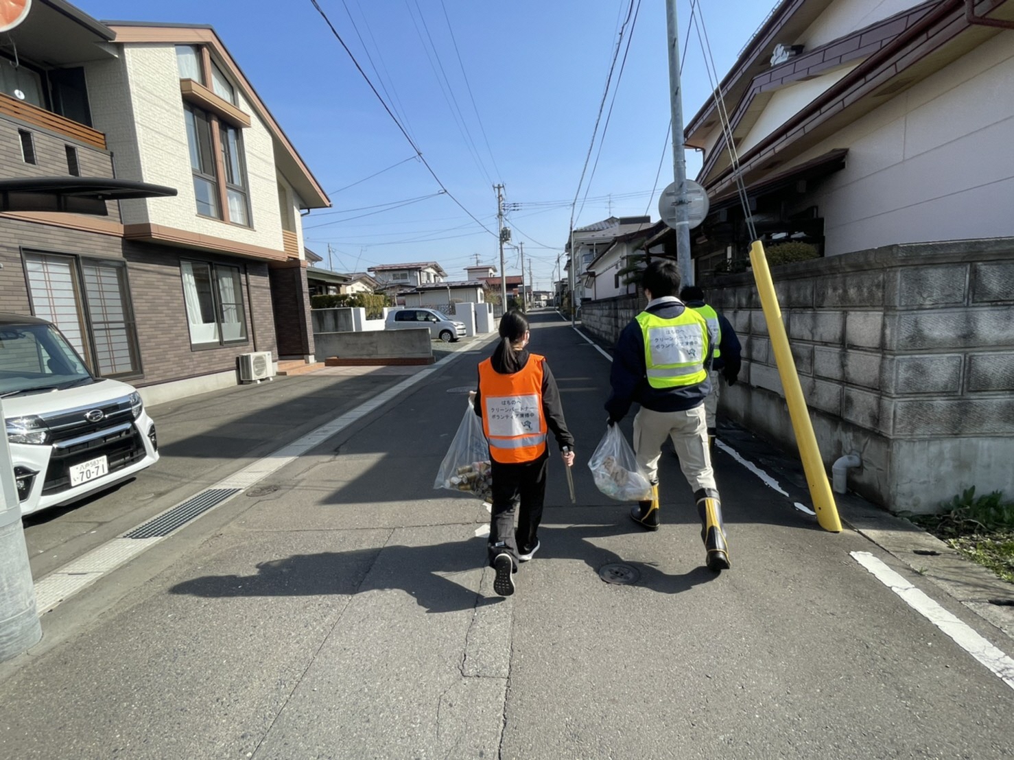 浅水川周辺住宅街の道路のごみを拾っている写真