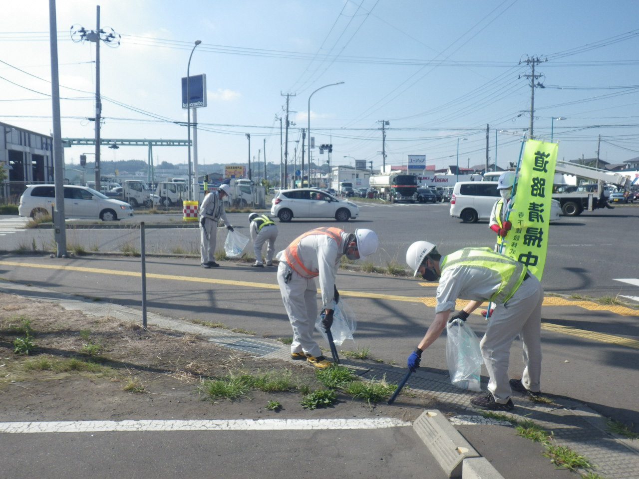 交差点付近を「道路清掃中」ののぼりを掲げごみひろい