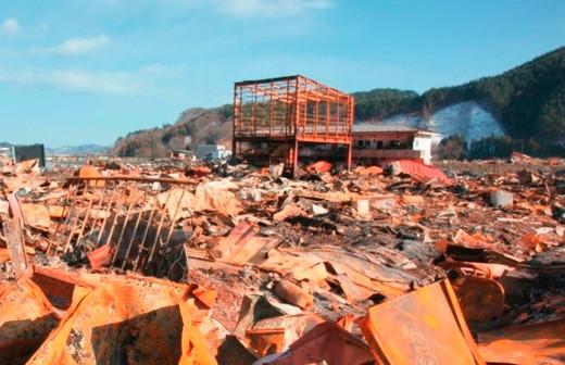 平成23年3月18日：瓦礫が散乱している中央で骨組みが残った建物が立っている写真