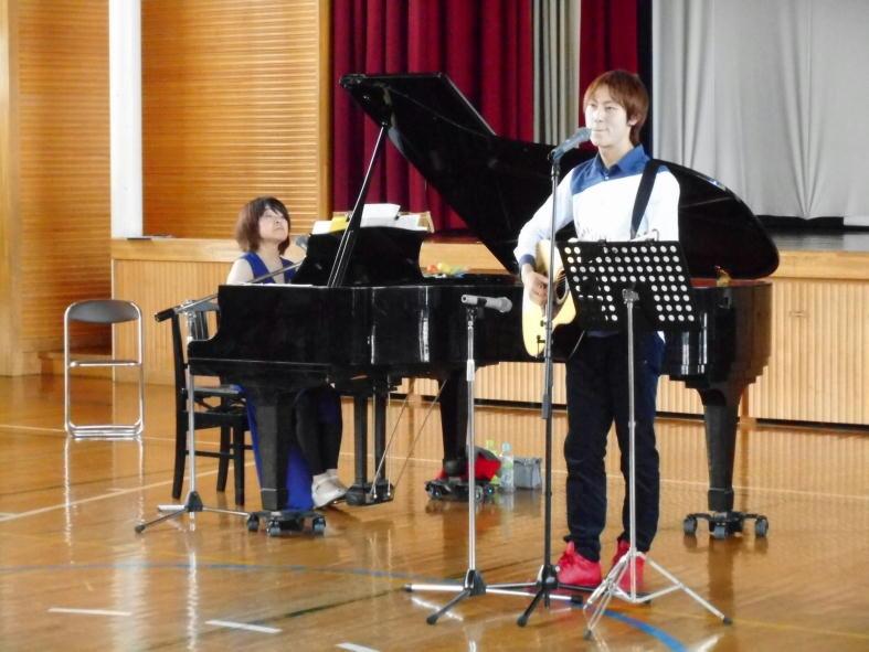 ピアノを弾いている豊嶋さんと、ギターを弾きながら歌っている中原さんの写真