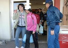 施設から外出する女性2名と隣に立っている男性の写真