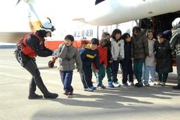 自衛隊のヘリコプターから降りて手をつないでいる児童たちの写真