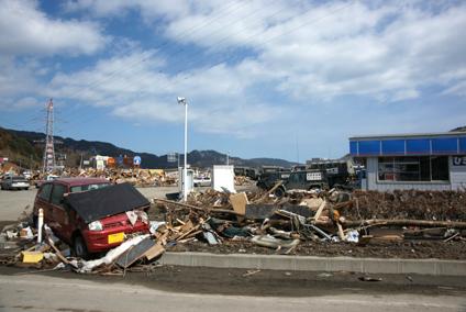 3月18日：被災した町の様子（左手前に赤い軽自動車、右にコンビニが写っている）