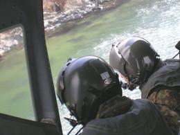 機内からのぞき込んで川の捜索をしている自衛隊員2名を機内から撮影した写真