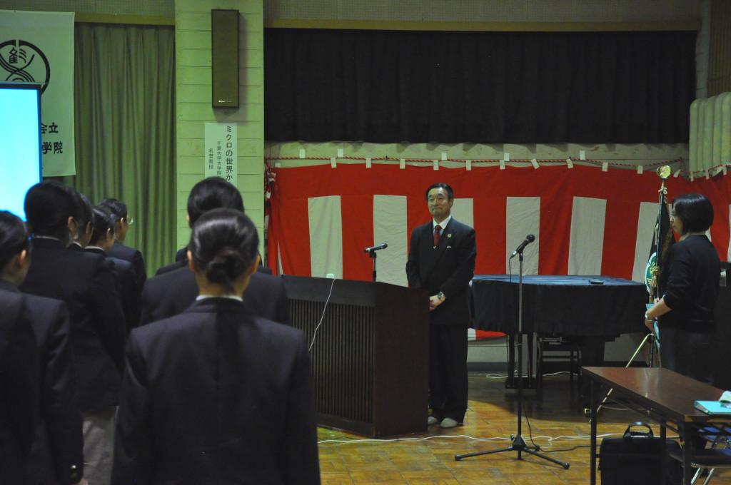 向かい合うように起立している生徒たちと野田先生の写真