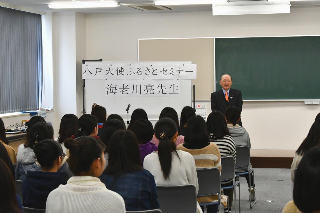 着席している学生たちの後姿と、前で話をしている海老川さんの写真