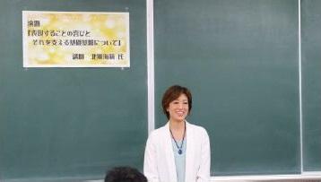 黒板の前で笑顔で立っている北翔さんの写真