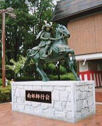 鎧兜を身に着けた南部師行が馬に乗っている銅像の写真