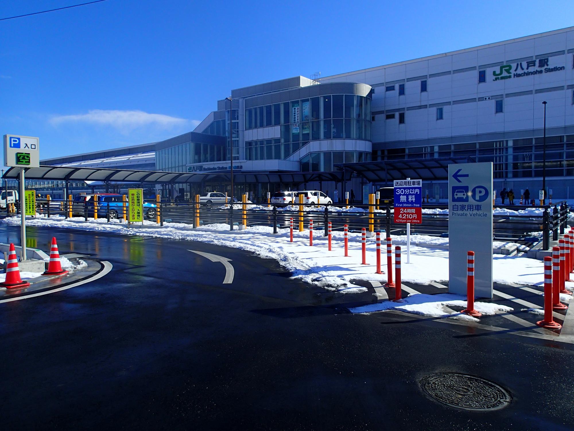 JR八戸駅前の平面駐車場入り口から駅全景を望む写真