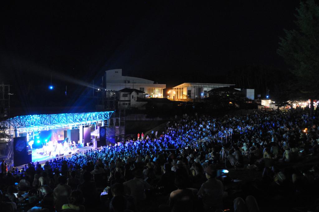 青いライトに照らされたステージを会場斜め後方から写した写真