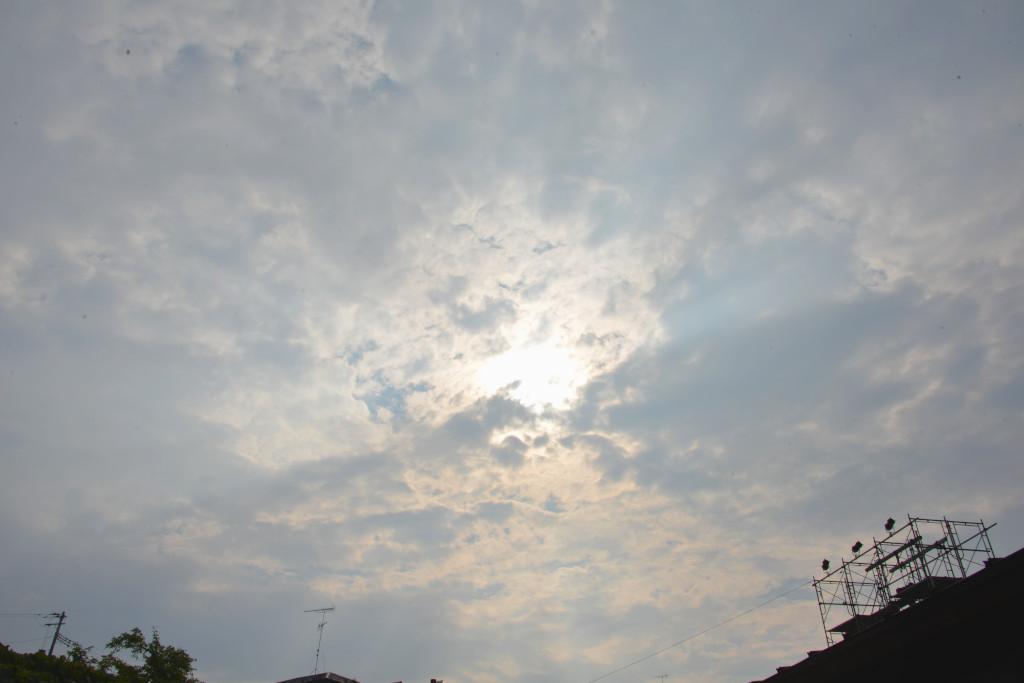 会場から見上げた空の雲から日が差し込んでいる写真