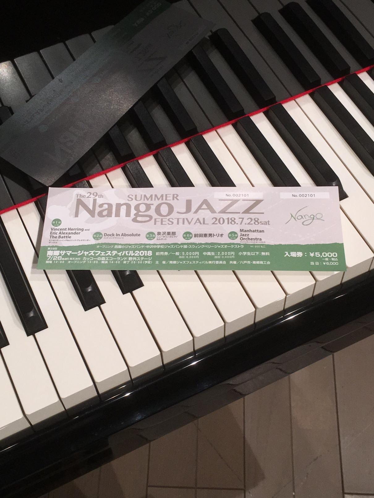 ピアノの鍵盤の上に置かれたサマージャズフェスティバル2018のチケットの写真