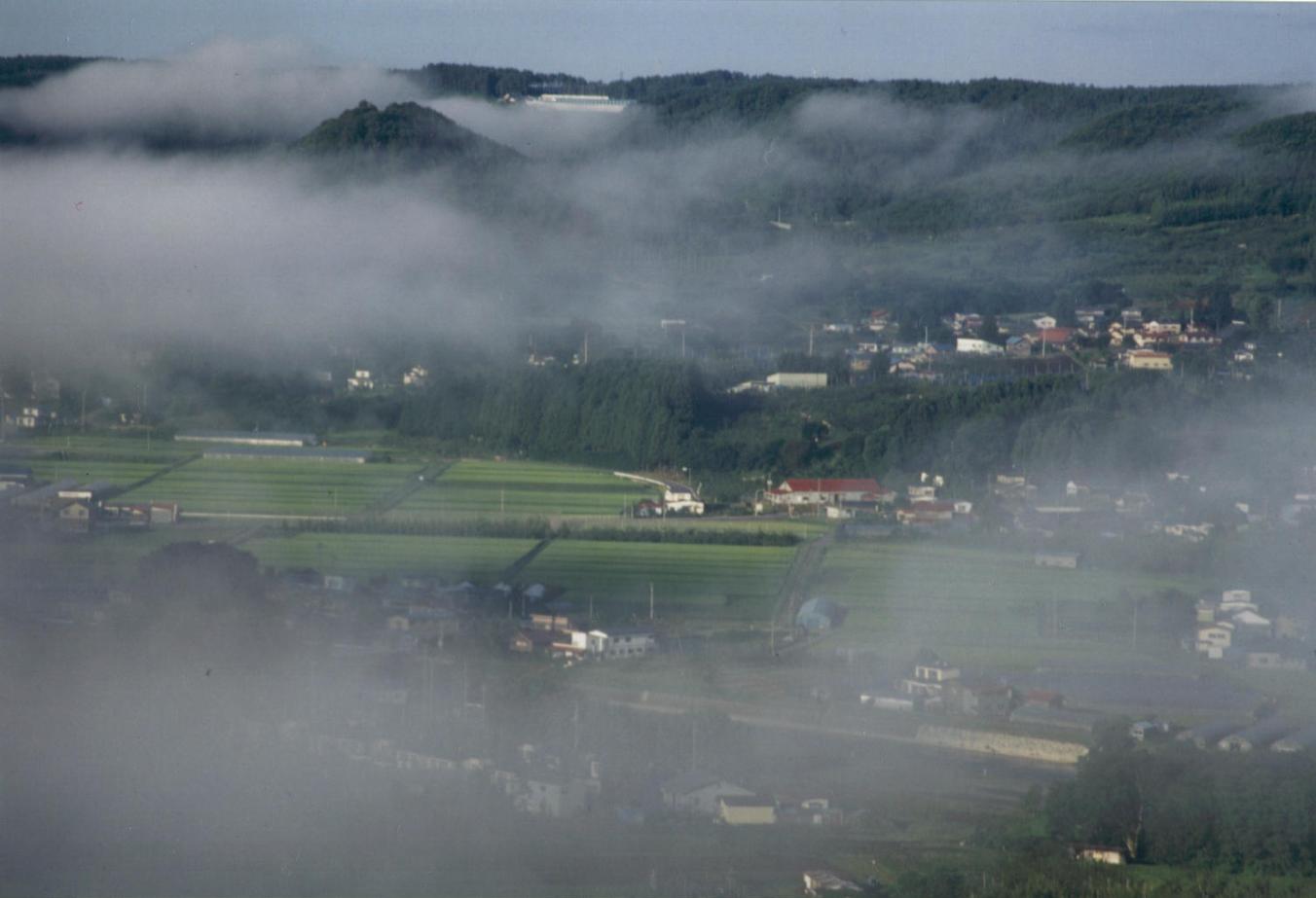 朝霧のかかる盆地を俯瞰する写真