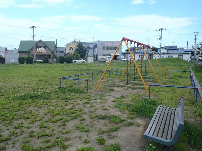 設置されたブランコの周囲に広がる広場と脇に設置されたベンチの小待公園全体の写真