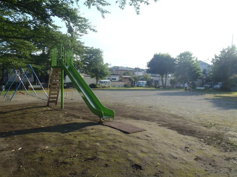 藤子公園の広場とブランコ・滑り台の写真