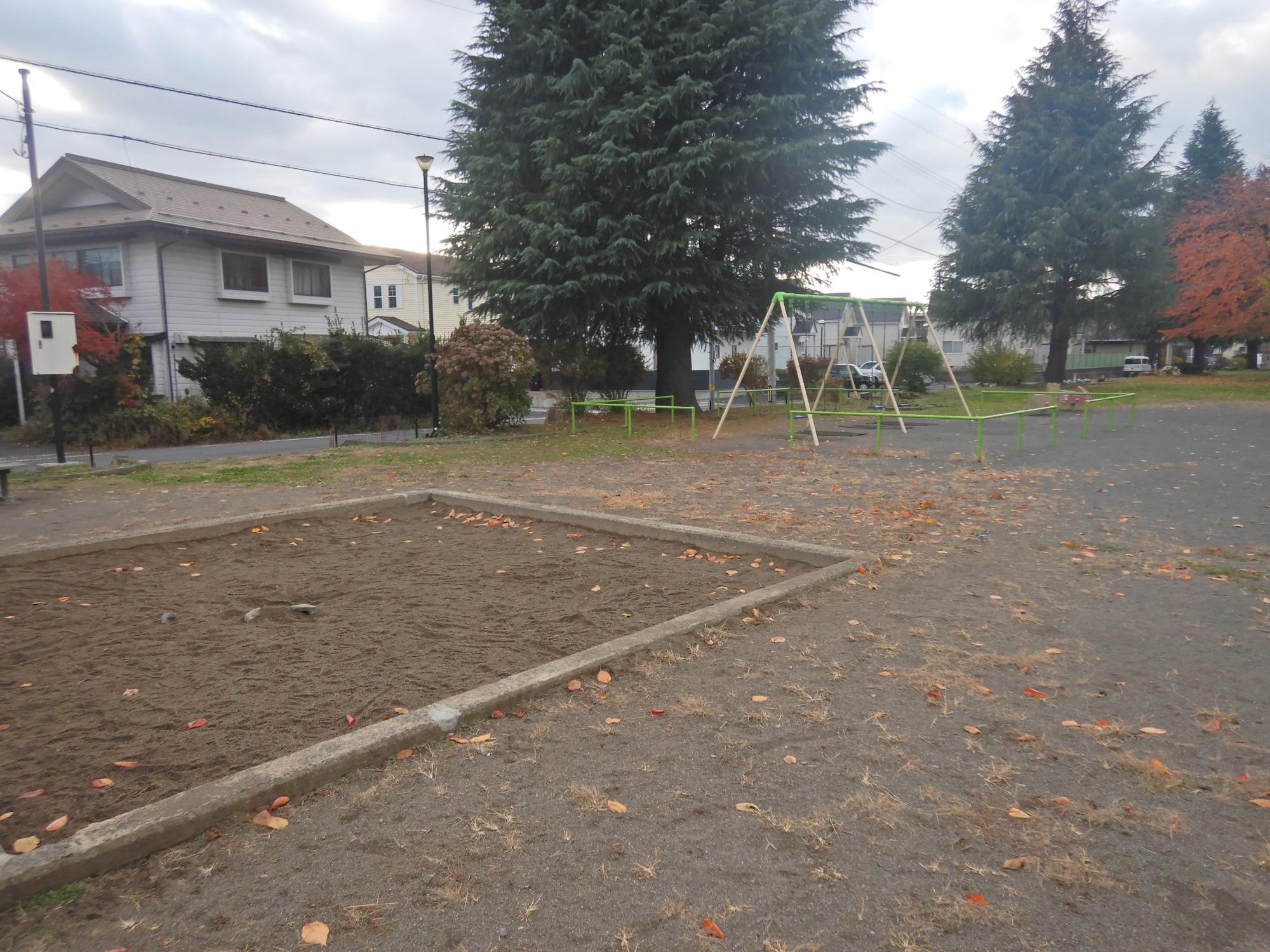 番屋平公園の砂場とブランコとスイング遊具の写真