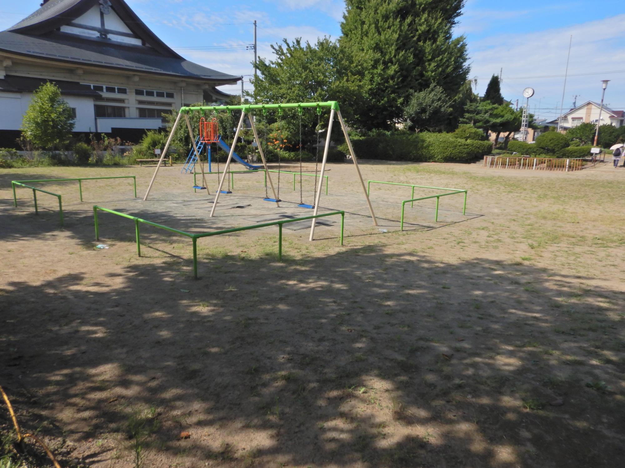 根城三丁目公園の広場とブランコ・滑り台の写真