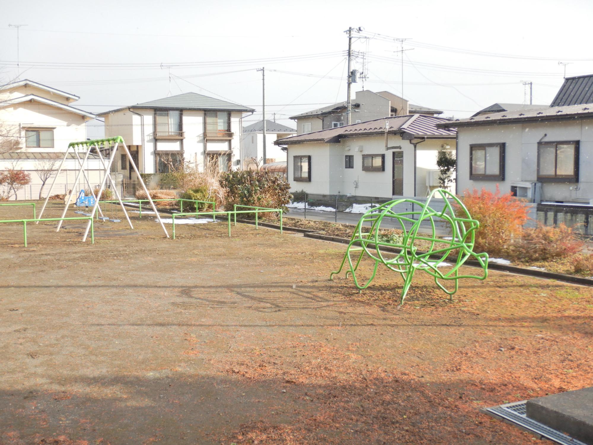 なかよし公園のブランコと恐竜ジャングルジムの写真