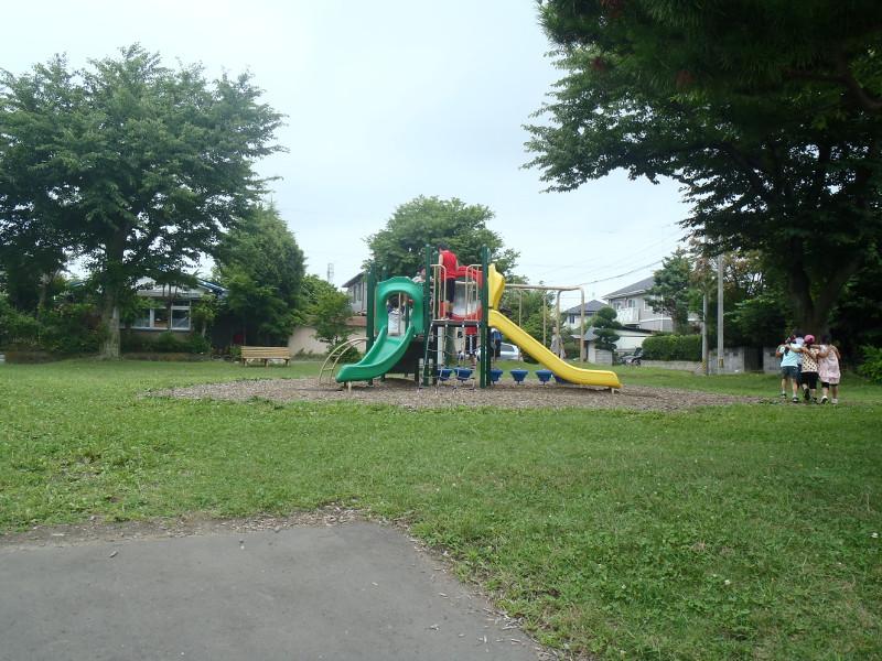 黄色や緑の滑り台が1つになった遊具を中心に撮影した旭ヶ丘五丁目公園の全体の様子の写真