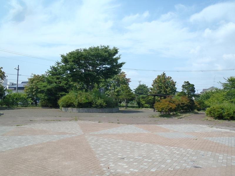 煉瓦で舗装され木々が植えられた湊高台中央公園の広場の写真