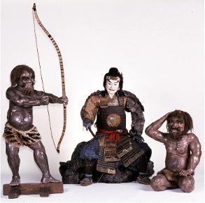 弓を構える人形と、鎧をまとい、岩に腰掛ける男の人形の写真