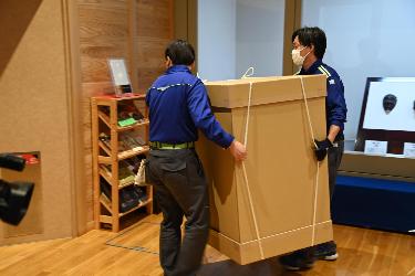 2人がかりで梱包された資料を運ぶ様子