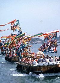 大漁旗をなびかせ、パレードをする沢山の船の写真